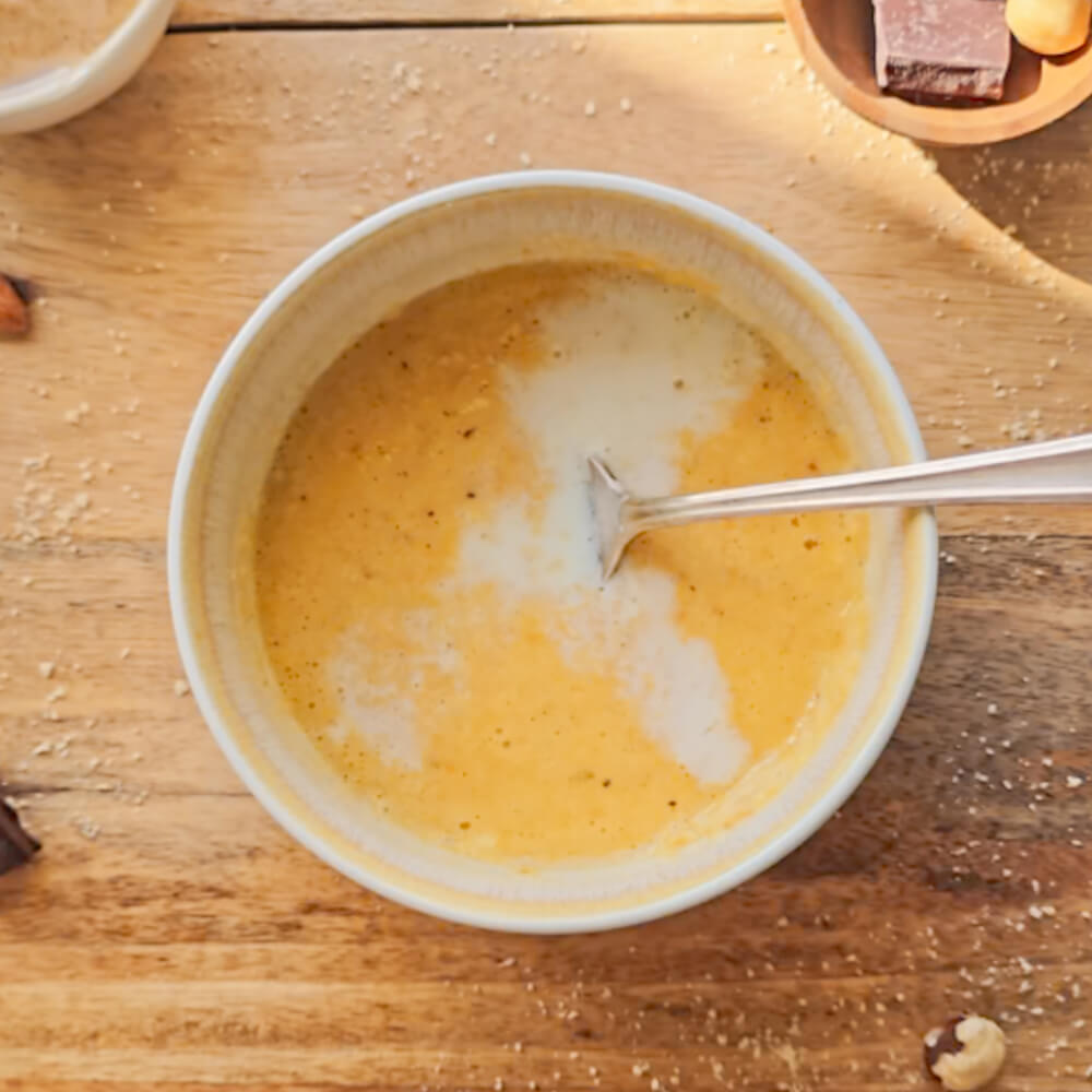 Versement de lait dans le mélange d'œuf et de sucre.