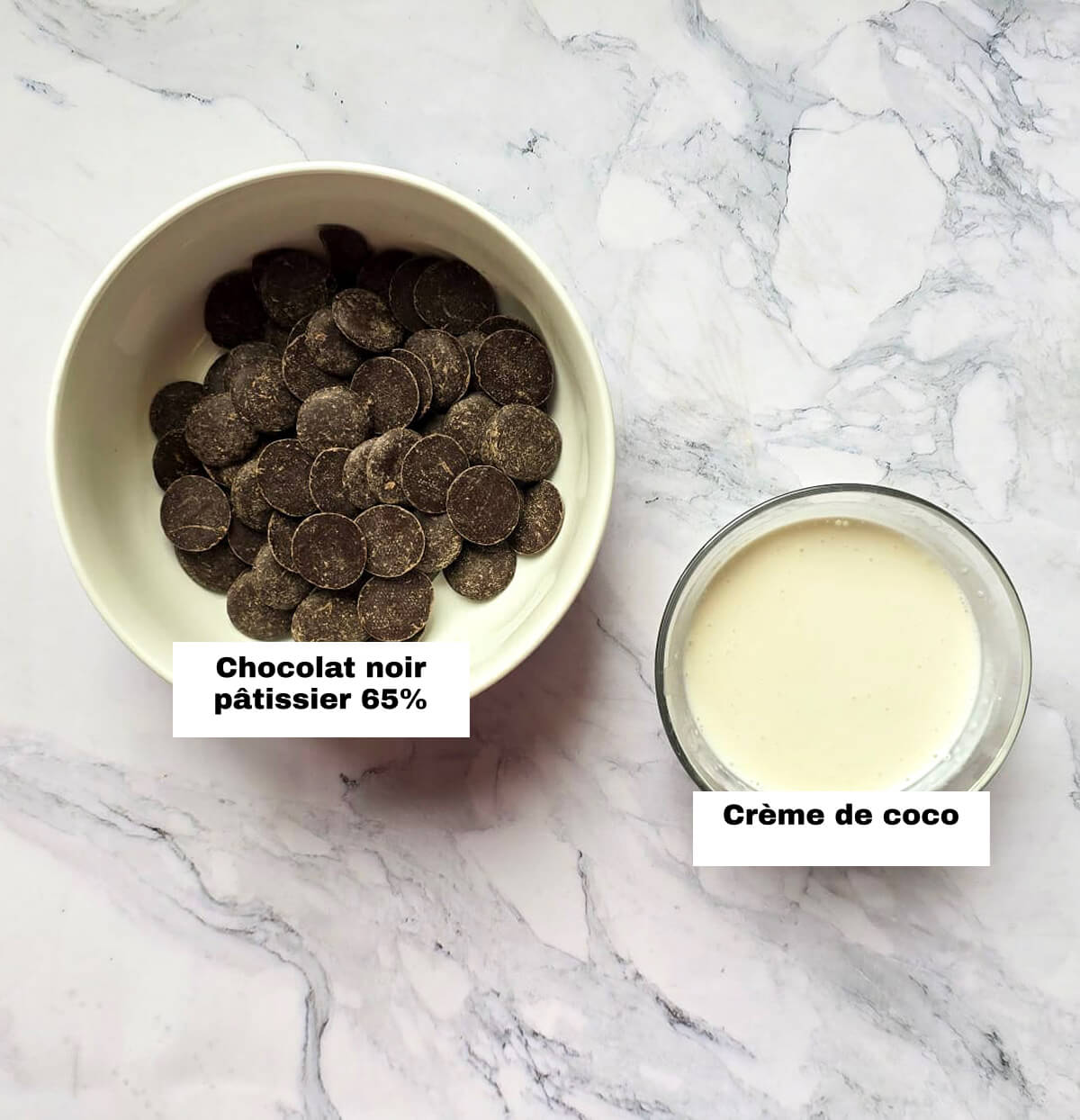 Du chocolat noir et de la crème de coco de coco dans leur contenant respectif sur un fond marbré blanc pour réaliser des crèmes chocolat lait de coco.