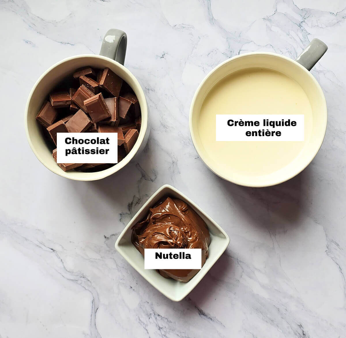Des ingrédients pour réaliser une ganache Nutella simple, sur fond blanc marbré.