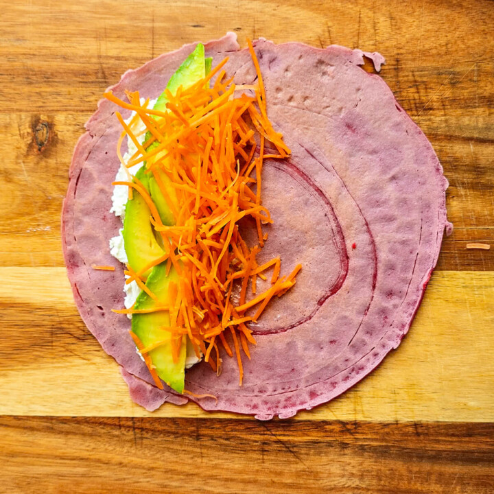 Préparation d'un wrap carotte, avocat et chevre, sur une planche de bois