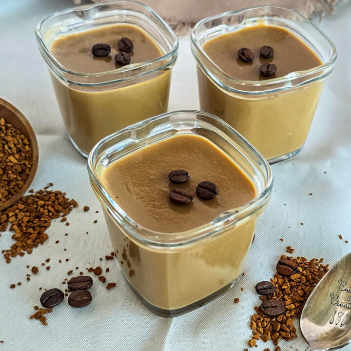 Des crèmes dessert au café soluble, grains de café et café soluble sur le coté.