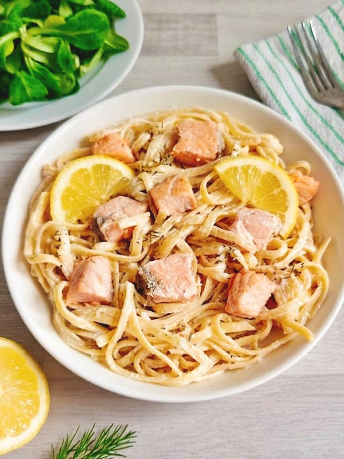 Assiette de tagliatelles au saumon healthy avec une sauce onctueuse au skyr, tranches de citron et aneth ciselé.