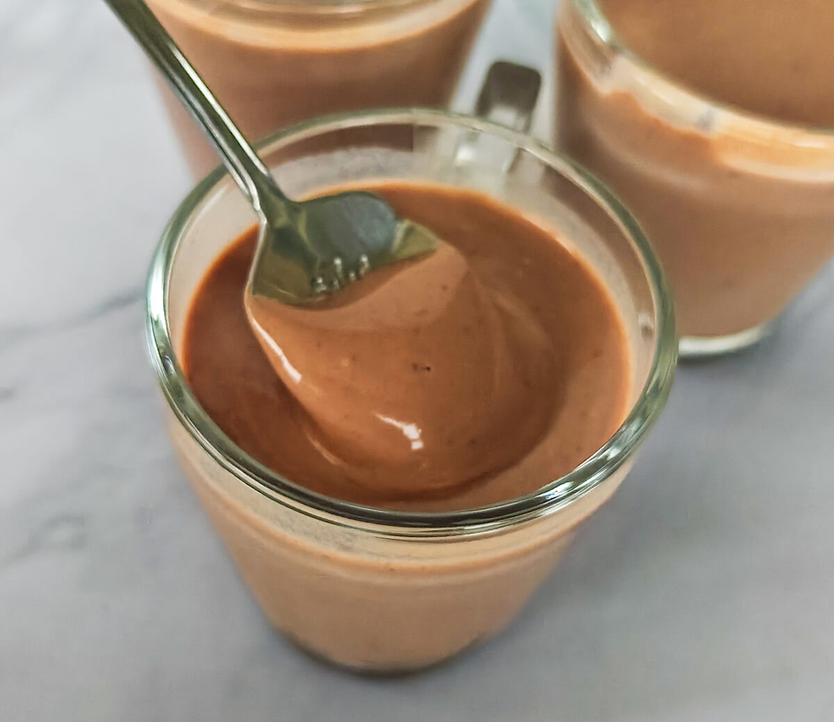 Une texture ultra crémeuse d'une crème dessert maison au chocolat dans une verrine en verre.