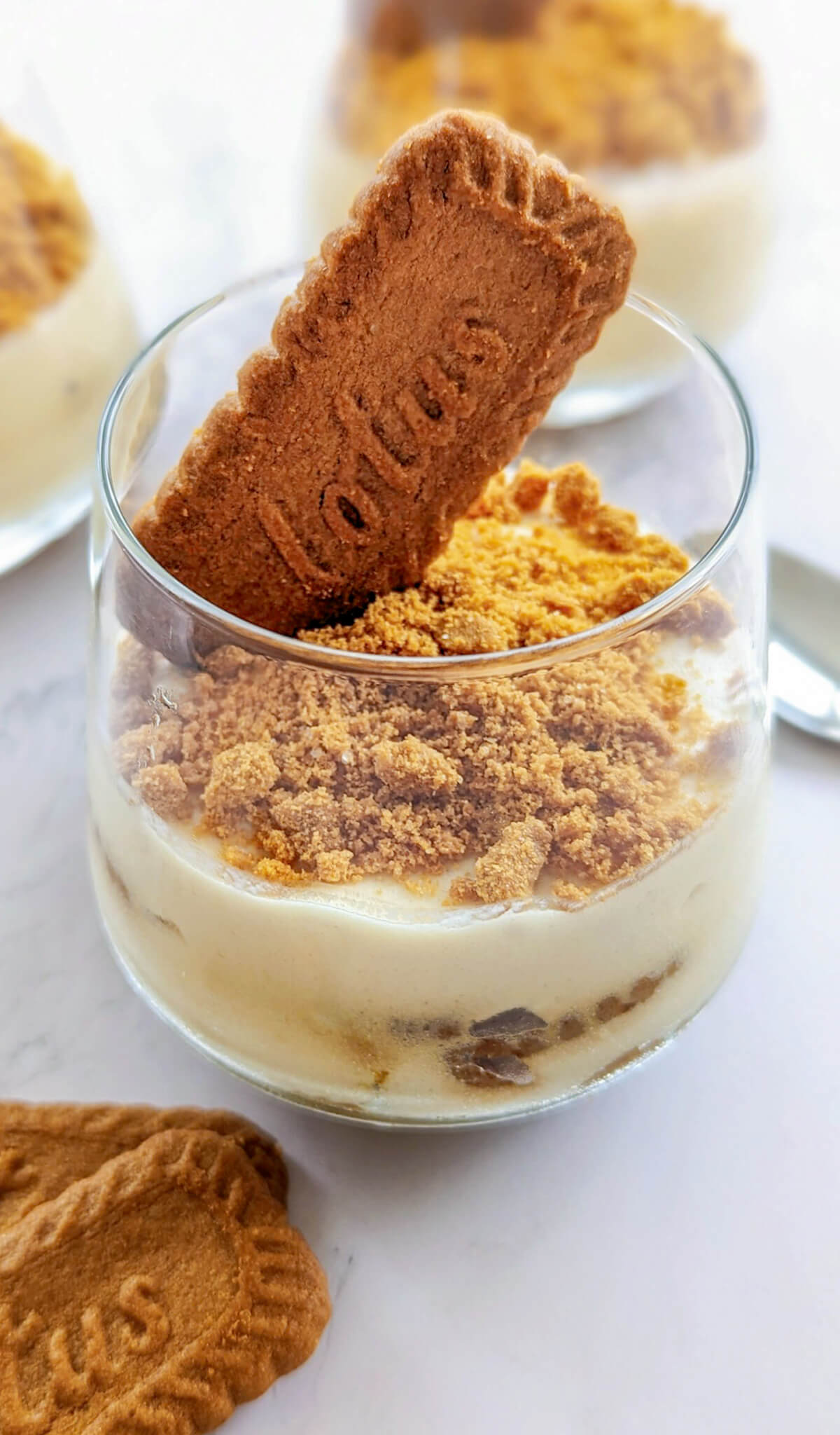 Verrine de tiramisu aux spéculoos avec une crème onctueuse, surmontée d'un biscuit Lotus entier et de miettes de biscuits croquants.