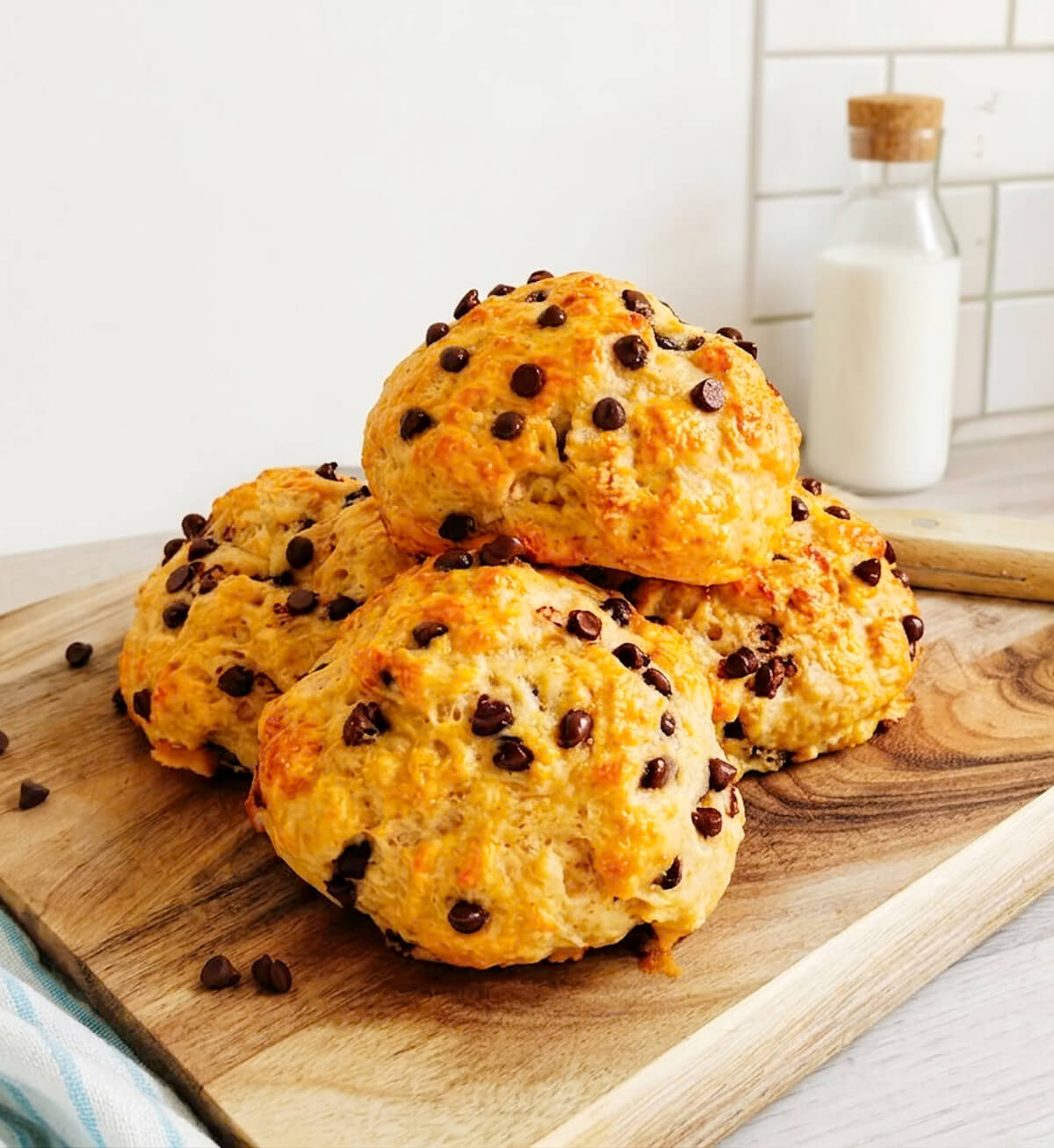 Des briochettes aux pépites de chocolat pour le goûter healthy, sur une planche de bois, torchon sur le côté, et couteau.