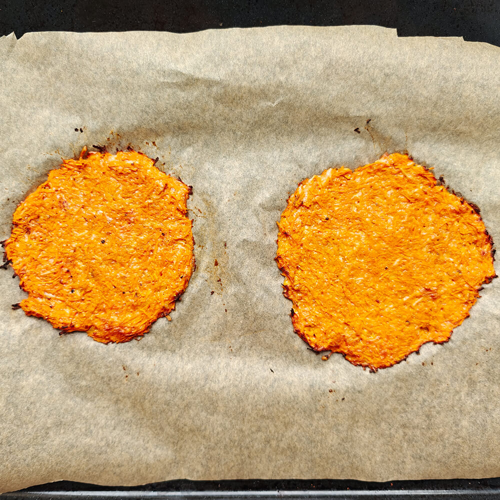 Deux tortillas de carottes cuites et dorées sur du papier sulfurisé, prêtes à être garnies pour une recette de wrap healthy.