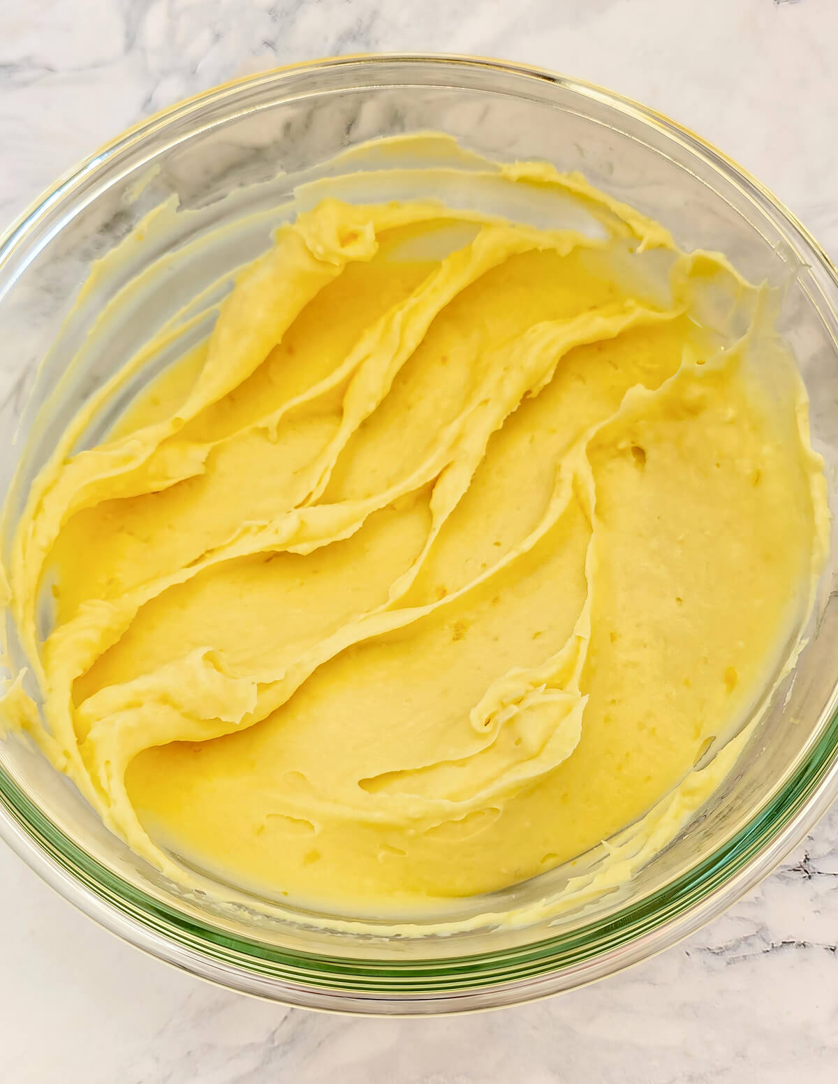 Texture finale onctueuse et jaune vif de la ganache au citron prête à l'emploi dans un bol.