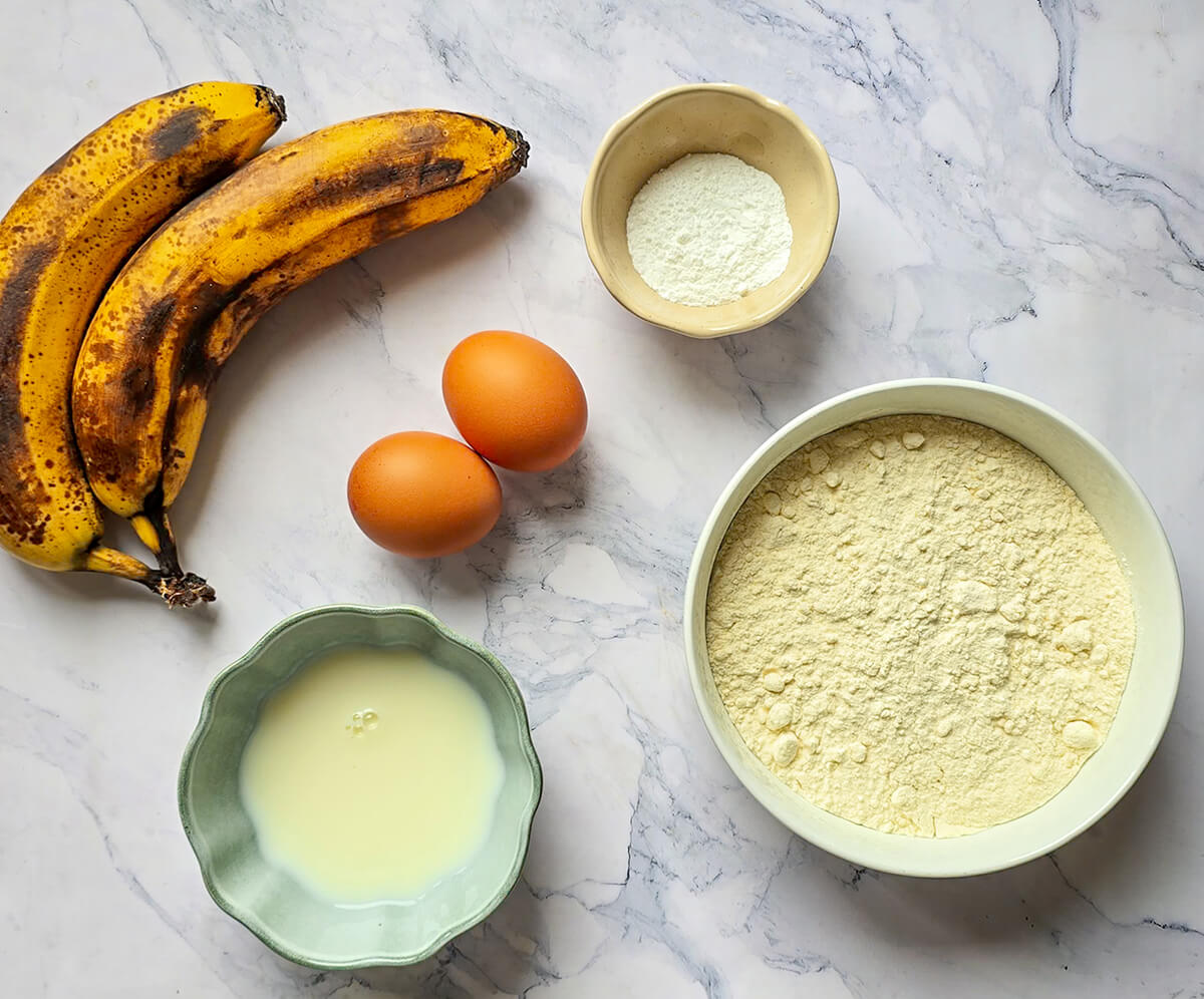 Des ingrédients pour faire une recette gaufre banane, sur un fond blanc marbré.