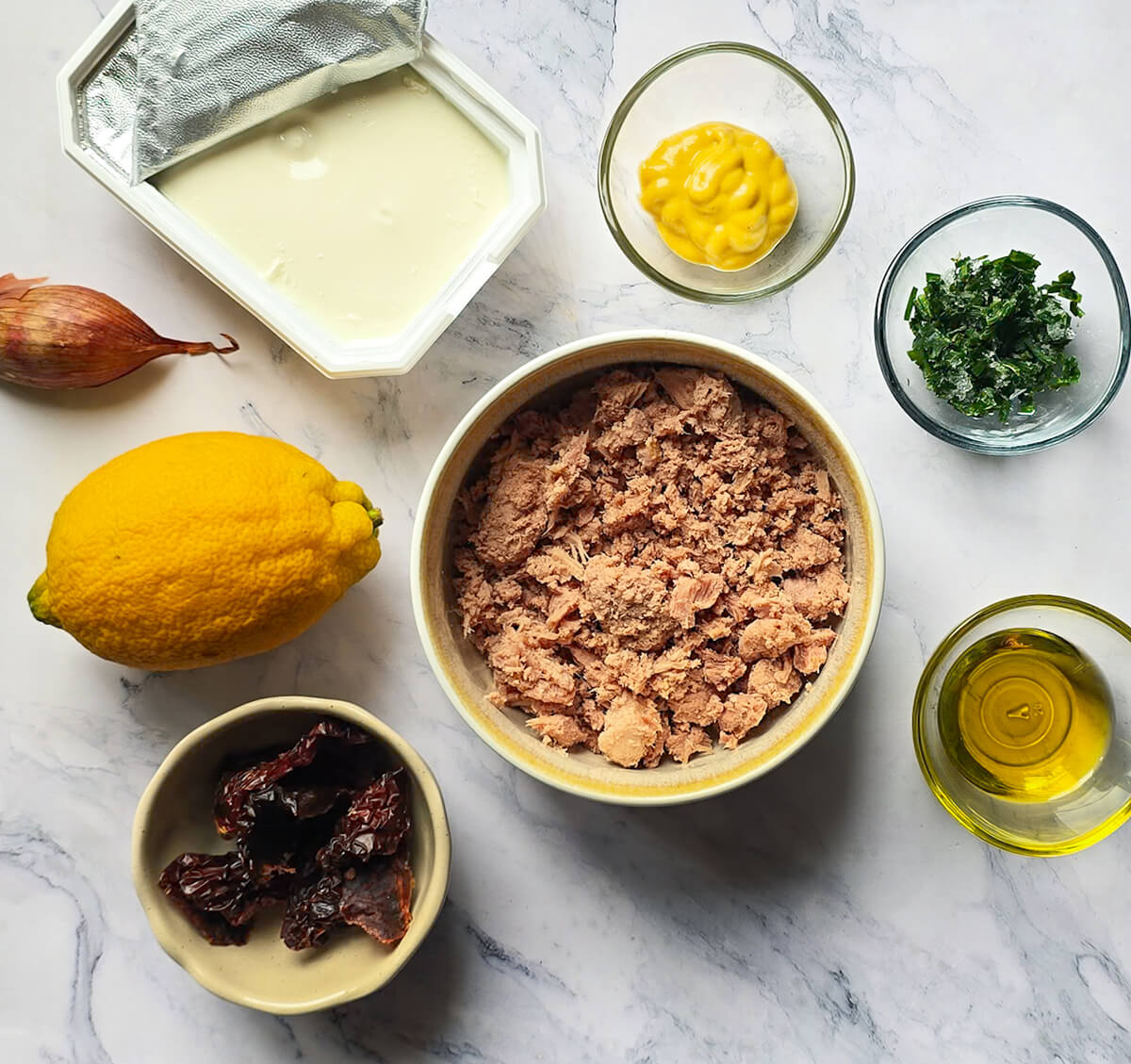 Des ingrédients pour préparer des rillettes, sur un fond blanc marbré.