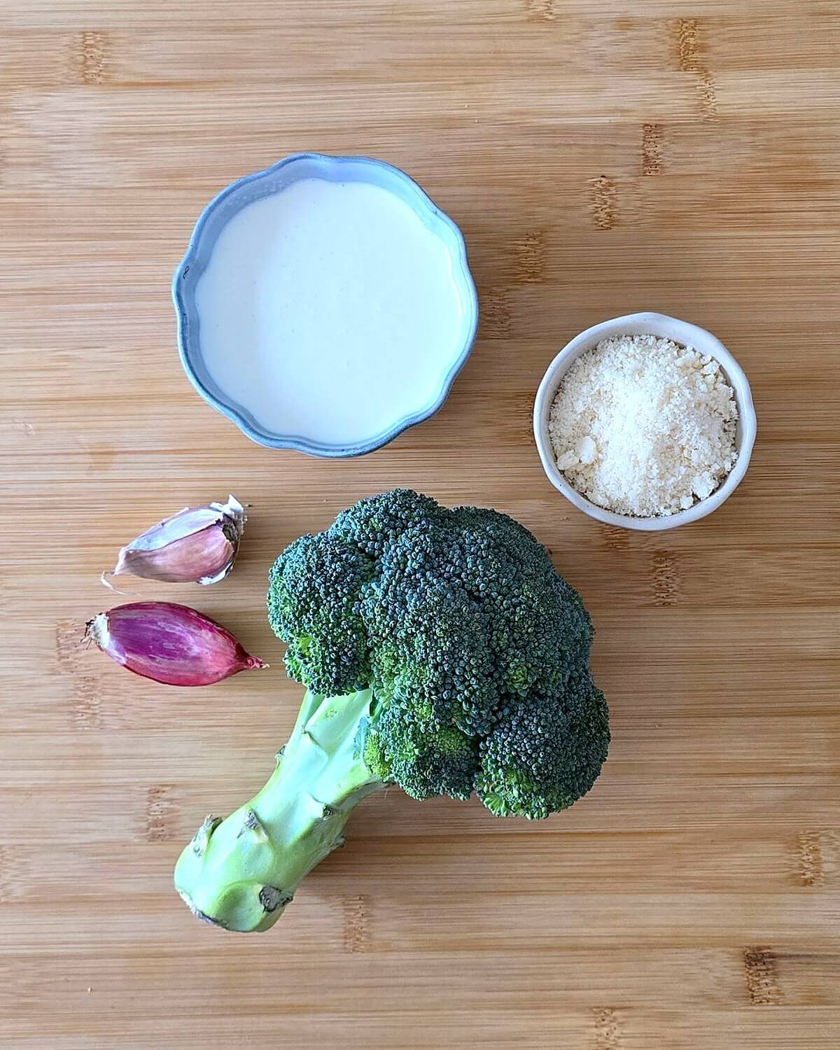 Des ingrédients pour réaliser une crème au brocoli, sur une planche en bois.