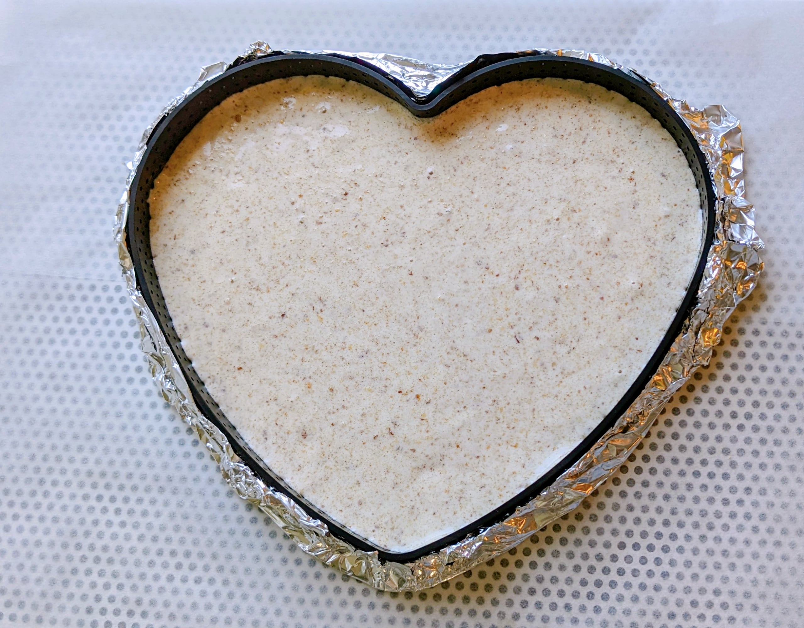 Un biscuit dacquoise dans son moule en forme de coeur pour un entremets au chocolat.