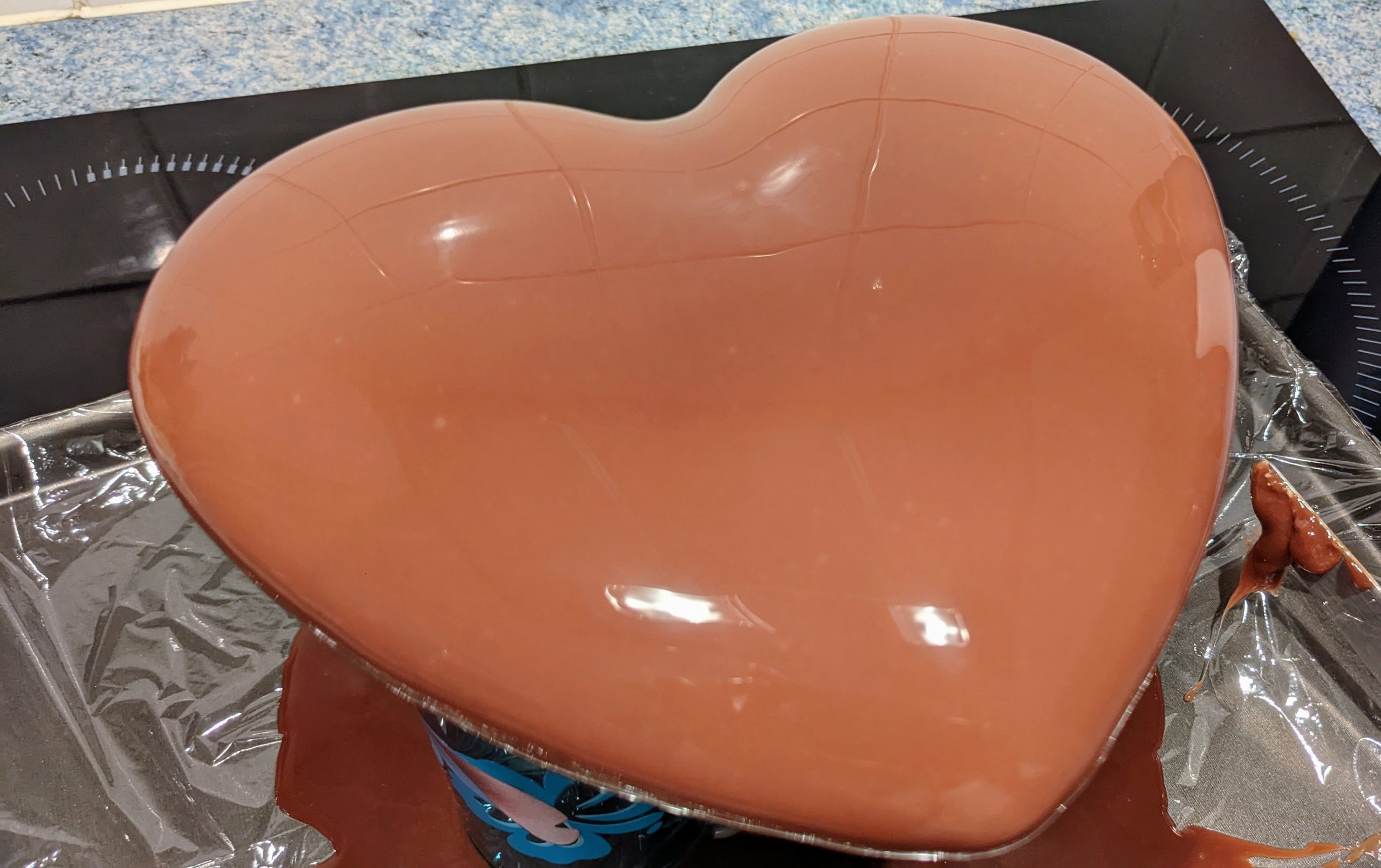 Un entremets chocolat en forme de cœur surélevé pour réaliser un glaçage.