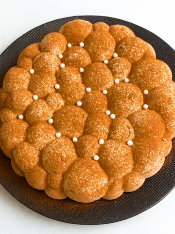 Une recette d'entremets aux 3 chocolats facile, dans une assiette noire.