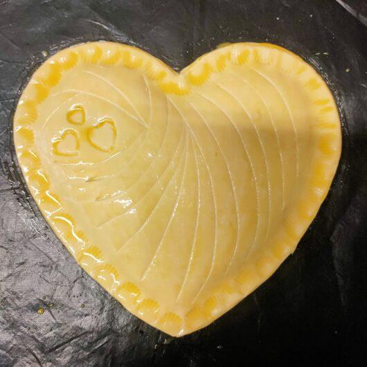 Pâte de galette des rois en forme de cœur avec jaune d'oeuf badigeonné 