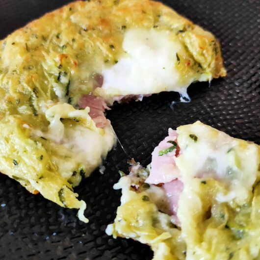 Intérieur d'une galette de courgettes au bacon sur une assiette noire