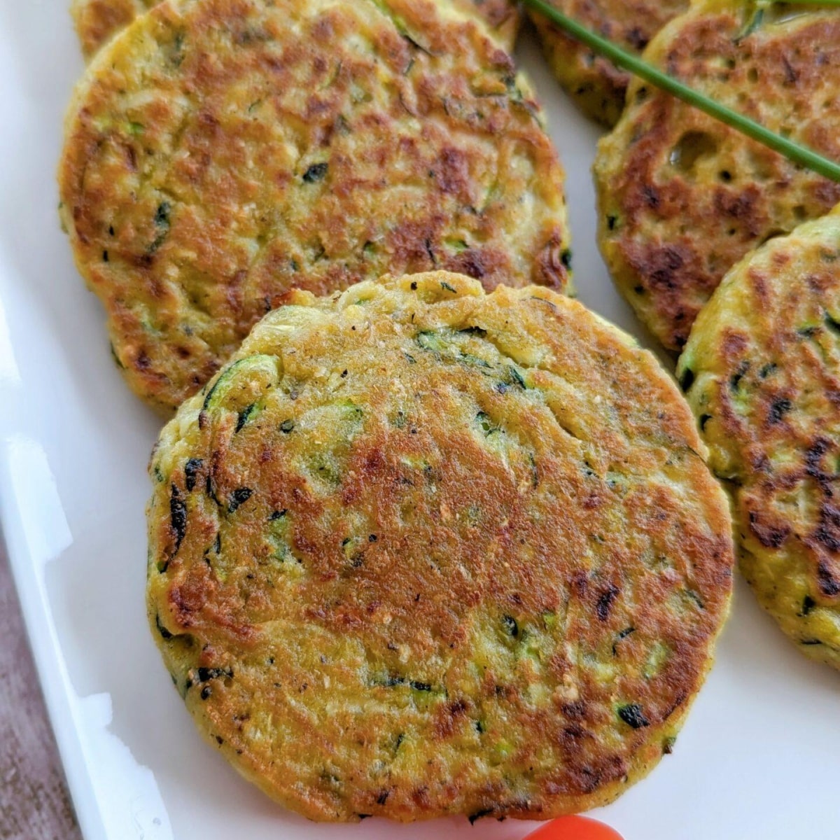 Des galettes de courgettes dans un plat blanc.