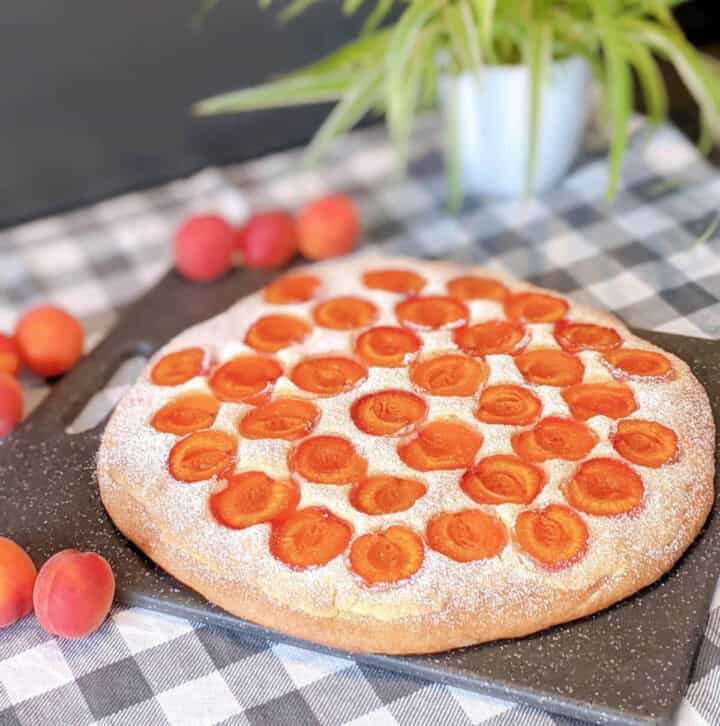 Brioche sur une planche à découper avec des abricots autour.