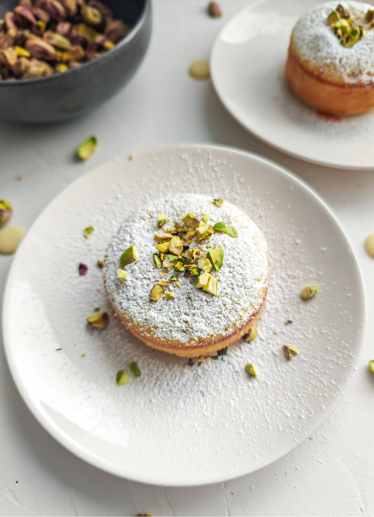 Un moelleux aux pistaches sur une assiette blanche, fourchette sur le coté.