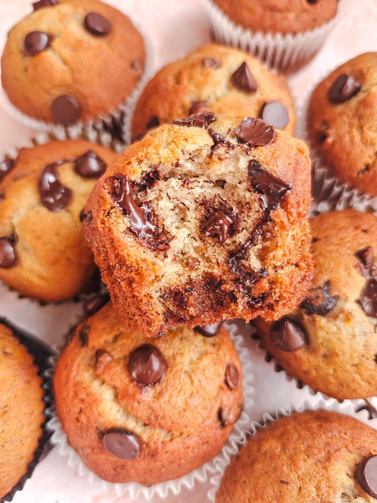 Un muffin ouvert en deux, avec d'autres muffins en arrière.