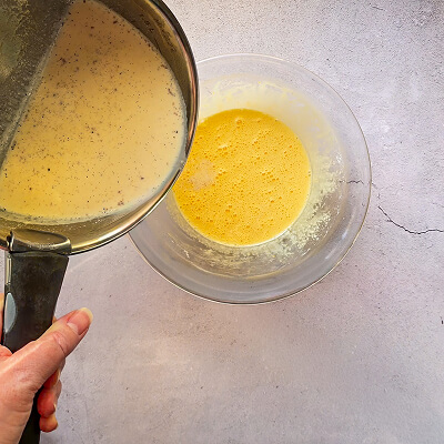 Une casserole et un saladier remplis d'ingrédients pour faire un appareil a flan.