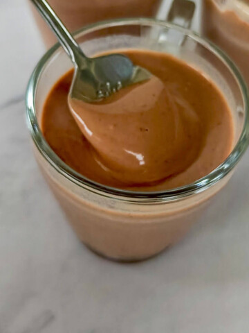 Une cuillère tenant une crème dessert chocolat sans œufs, facile et rapide à réaliser.