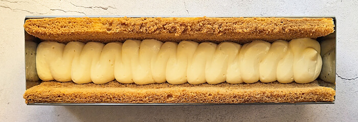 étaler-creme-mascarpone-buche-tiramisu (1) Étaler de la crème mascarpone dans le moule.