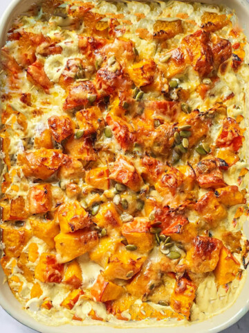 Un gratin crémeux de potimarron et champignons dans un plat allant au four.