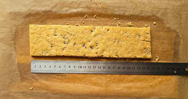 Couper le sablé aux noix de pécan pour une bûche de Noël.