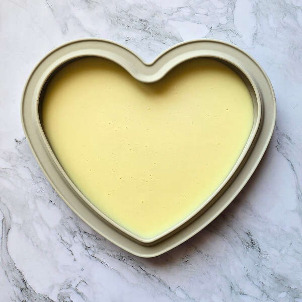 Insert-namelaka-congelé-entremets-fraises-glacage-miroir-rouge Un insert namelaka dans un moule en silicone en forme de cœur pour un entremets fraise.