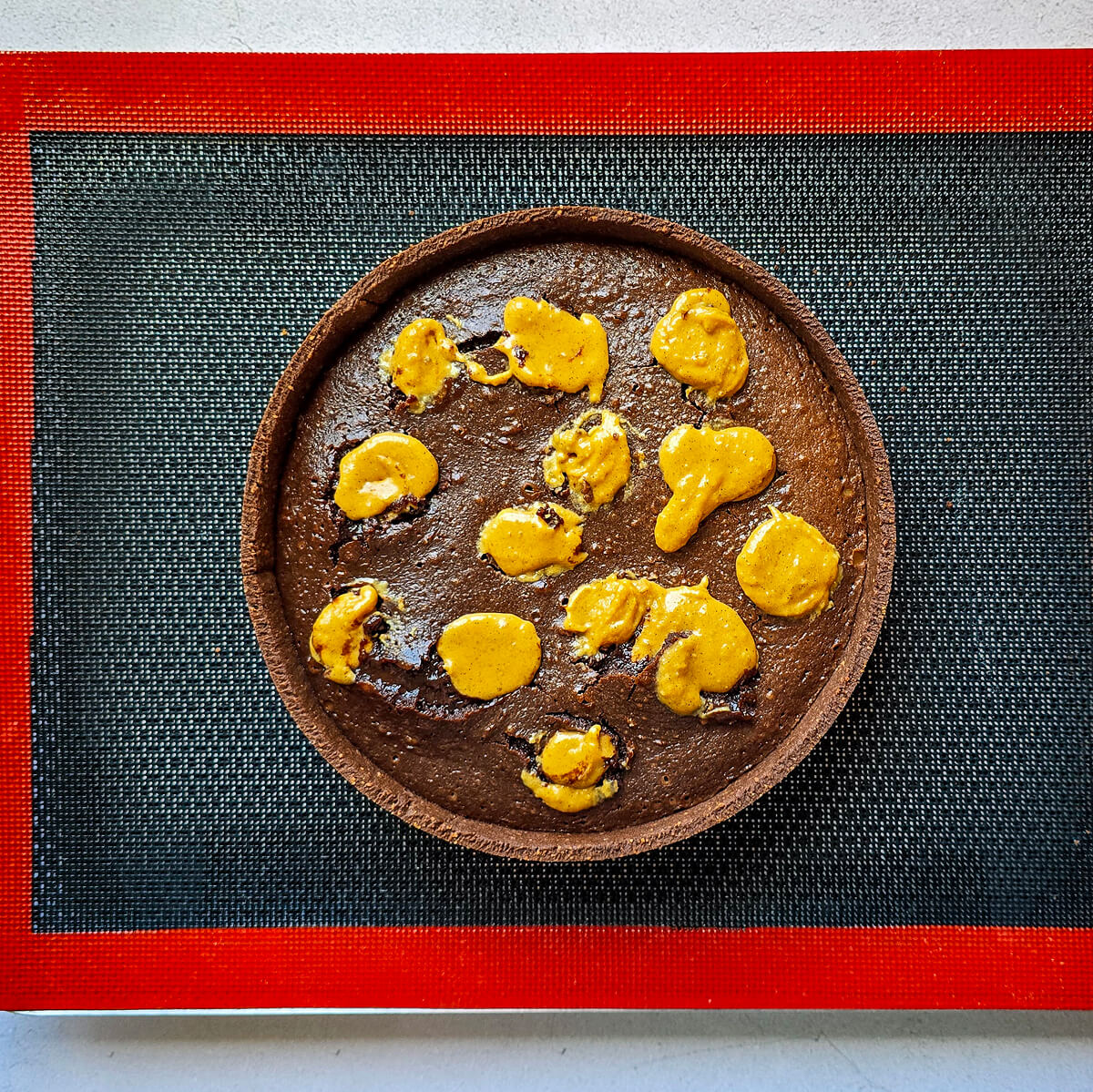 ajouter praliné cacahuètes pour tarte snickers (1) Ajout du praliné cacahuètes sur la tarte snickers.