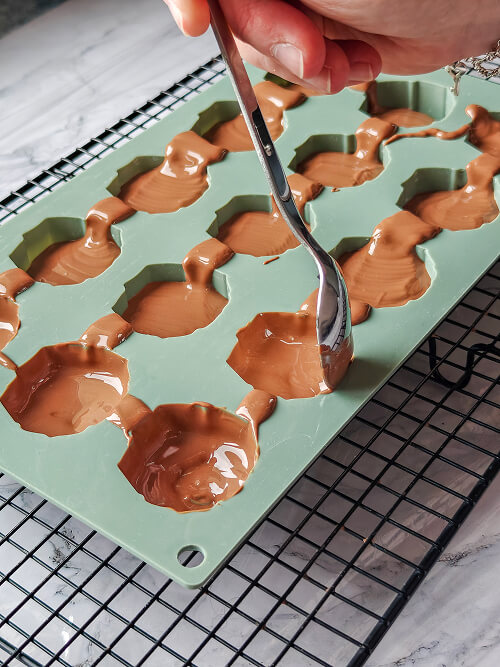 etaler-chocolat-moule (1) Étaler le chocolat fondu dans les moules.