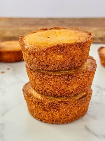 Pile de trois palets bretons maison dorés et croustillants, disposés sur un plan de travail en marbre blanc, recette traditionnelle de biscuits pur beurre.