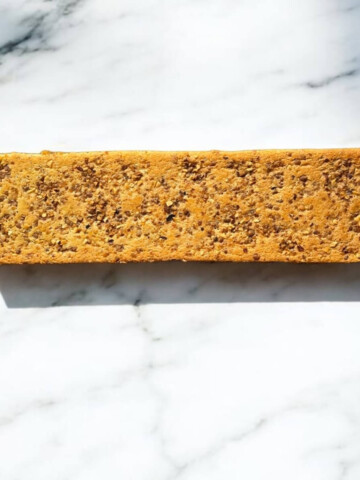 Un biscuit joconde noisette sur un fond marbré blanc.