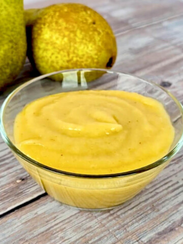 Du curd poire facile et gourmand, dans une coupelle en verre, poires à l'arrière.