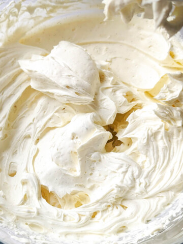 Gros plan sur une ganache montée à la vanille onctueuse et parsemée de grains de vanille noire.