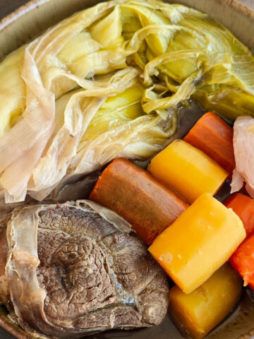 Gros plan d'une assiette de pot-au-feu aux légumes d'hiver et bœuf braisé, plat réconfortant de la cuisine française.