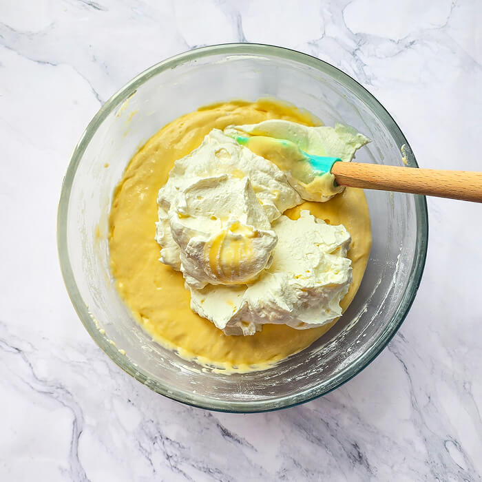 ajouter-chantilly-préparation Incorporation de la crème chantilly à la préparation du Molly Cake avec une maryse pour obtenir une pâte mousseuse et légère.