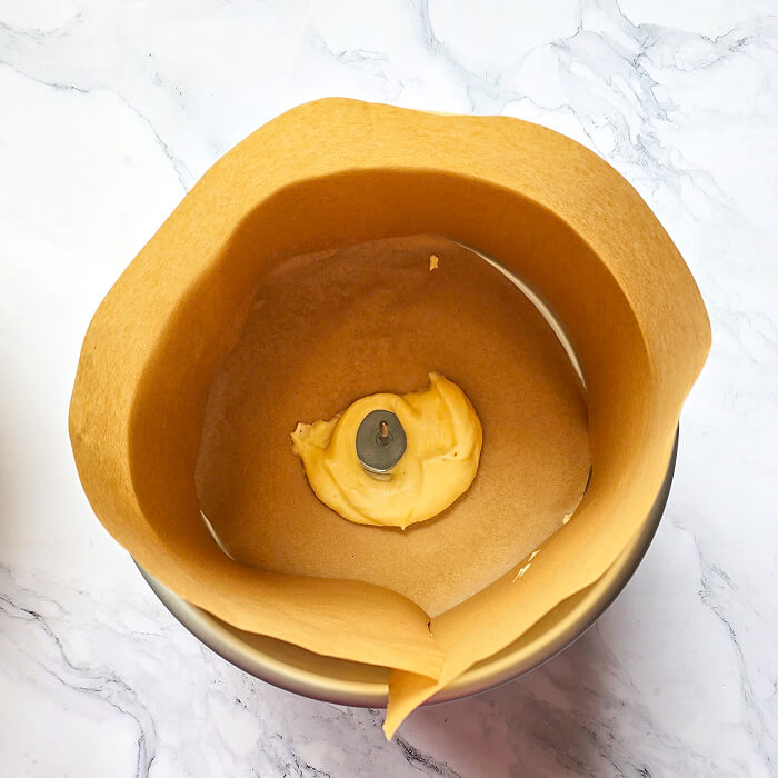 chemiser-moule-clou-fleurs Moule à gâteau chemisé de papier sulfurisé avec un clou à fleur central pour assurer une cuisson homogène du Molly Cake.