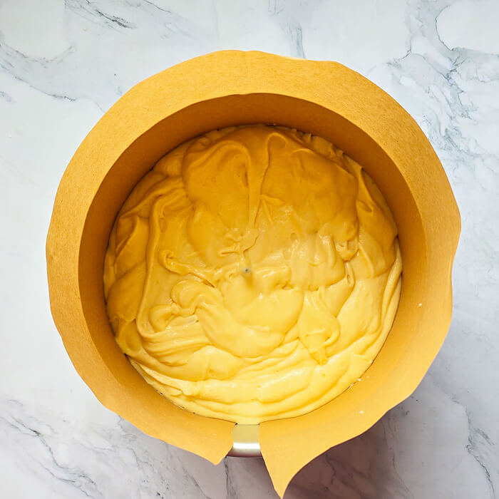 cuire-molly-cake Pâte à Molly Cake versée dans un moule haut chemisé, prête à être enfournée pour obtenir un biscuit bien gonflé et régulier.