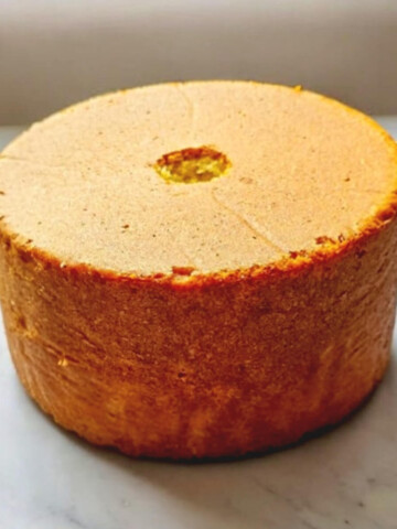 Un molly cake facile après cuisson, haut et léger sur une surface blanche marbré.