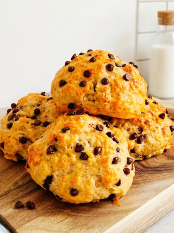 Des briochettes aux pépites de chocolat pour le goûter healthy, sur une planche de bois, torchon sur le côté, et couteau.