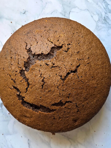 Un gâteau chiffon cake au cacao sur une surface blanche marbrée.