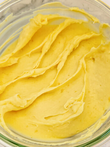 Texture finale onctueuse et jaune vif de la ganache au citron prête à l'emploi dans un bol.