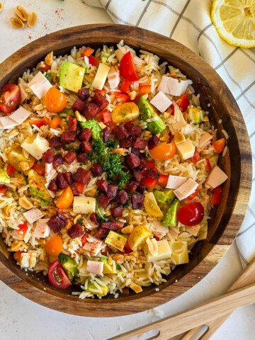 Une salade Tex-Mex dans un bol en bois, avocat, citron et tomates cerises sur les côtés.